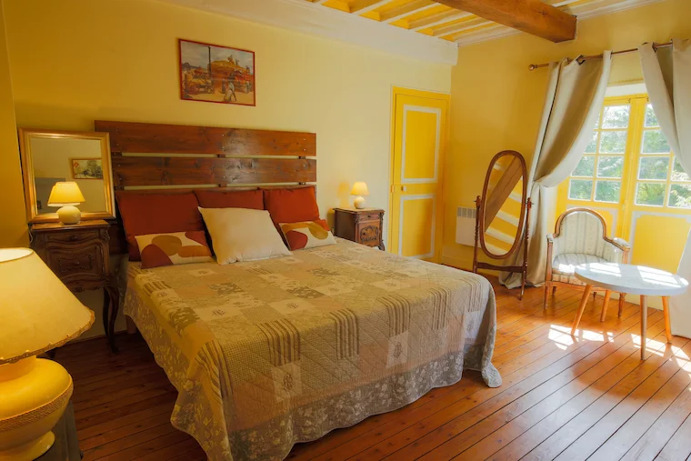 La Chambre Renoir, chambre lumineuse aux tons jaunes avec lit double et mobilier ancien